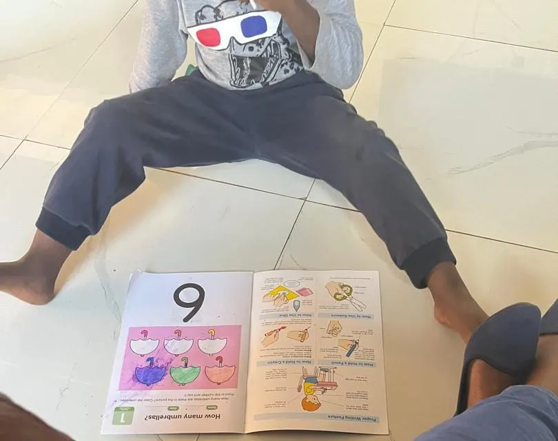 A child sitting on the floor with an open activity book