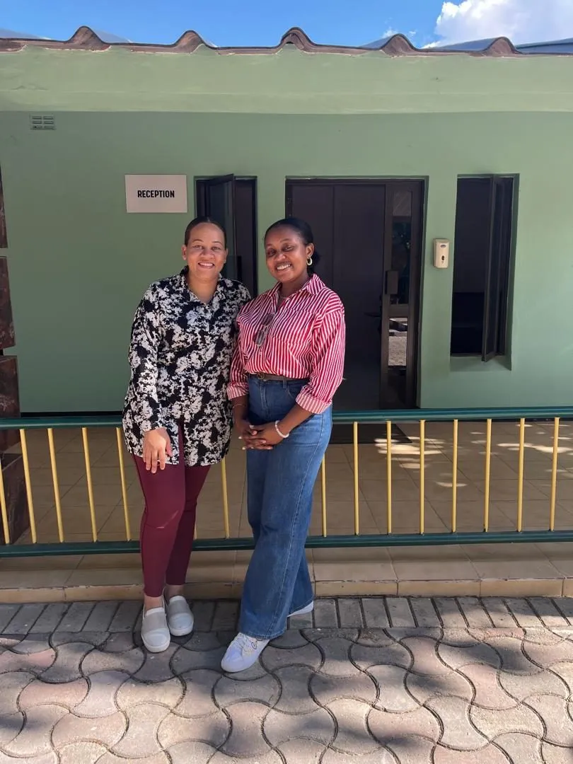 Two staff members smiling outside a reception building