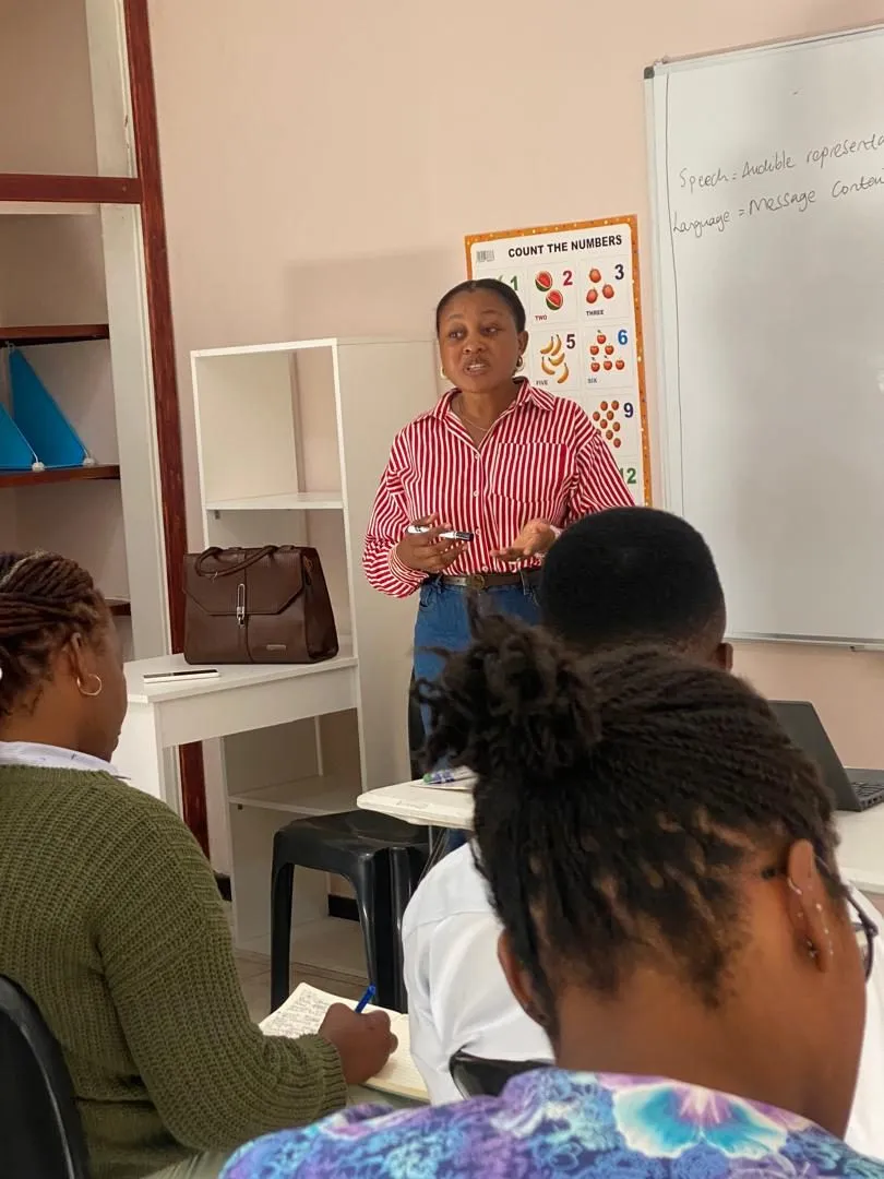 A facilitator leading a training session in front of a whiteboard