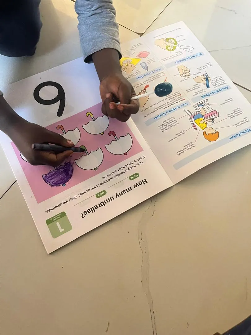 A child colouring in a number activity book